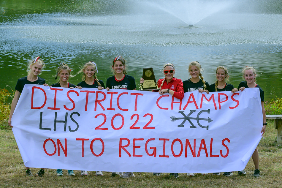 the 2022 Lovejoy High School XC Varsity Girls with Coach Littlefield and hardware